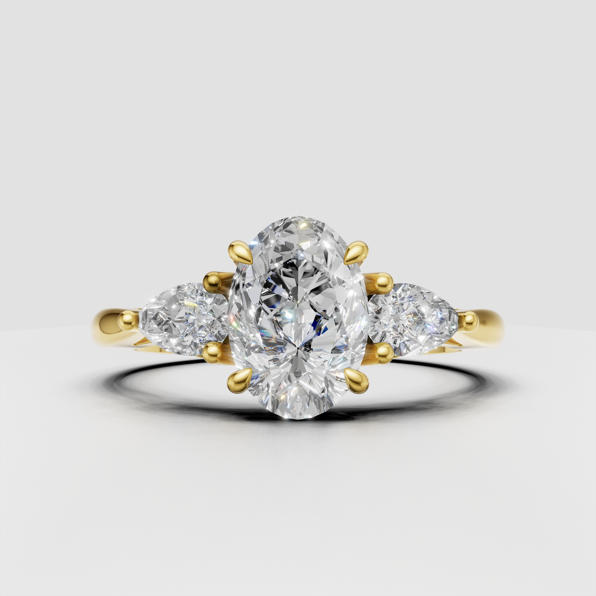 Oval diamond three-stone engagement ring in polished yellow gold