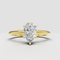 Pear diamond cathedral engagement ring with polished yellow gold band