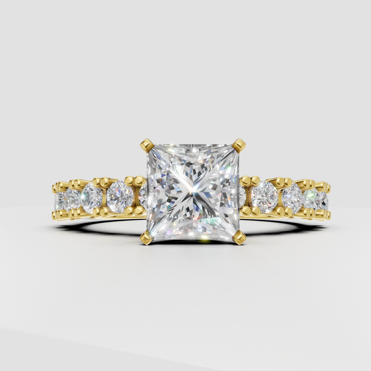Princess cut diamond four-prong yellow gold engagement ring with pavé side stones