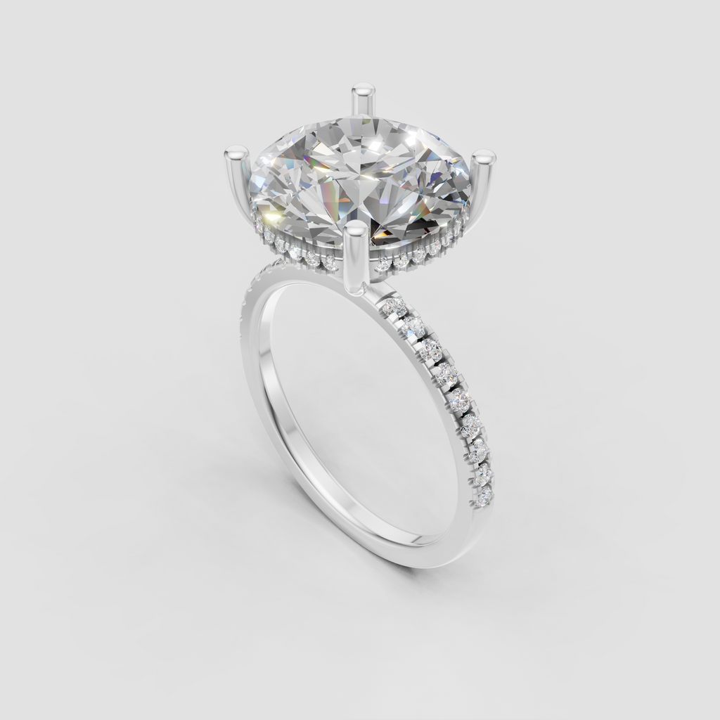 Close-up round brilliant diamond ring showcasing four gold prongs and hidden halo detailing.