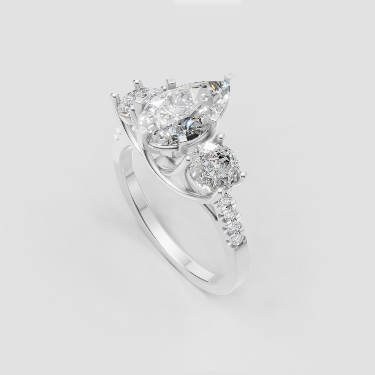 Pear diamond three stone ring with sparkling diamond-accented shoulders