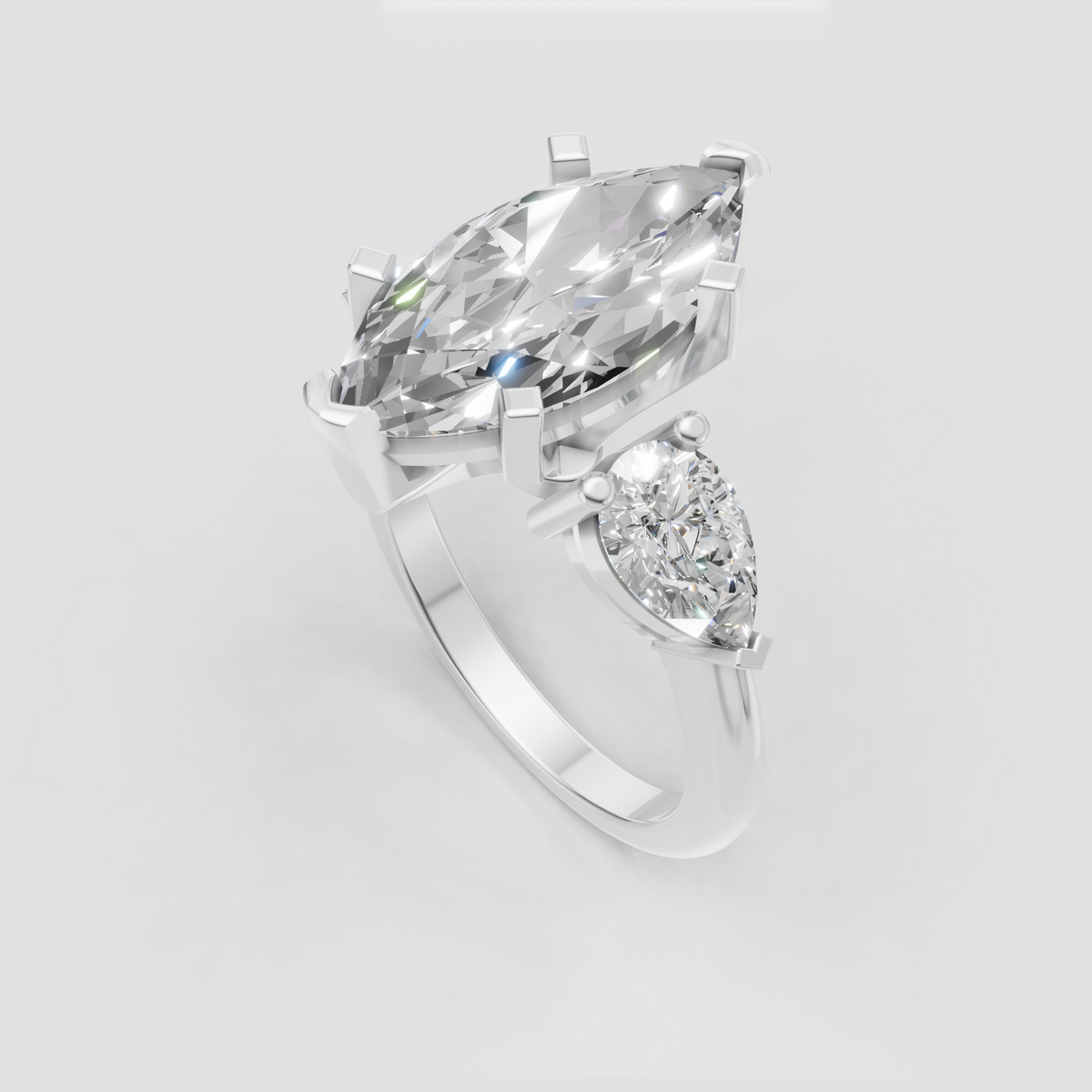 Three stone engagement ring featuring marquise and pear diamonds