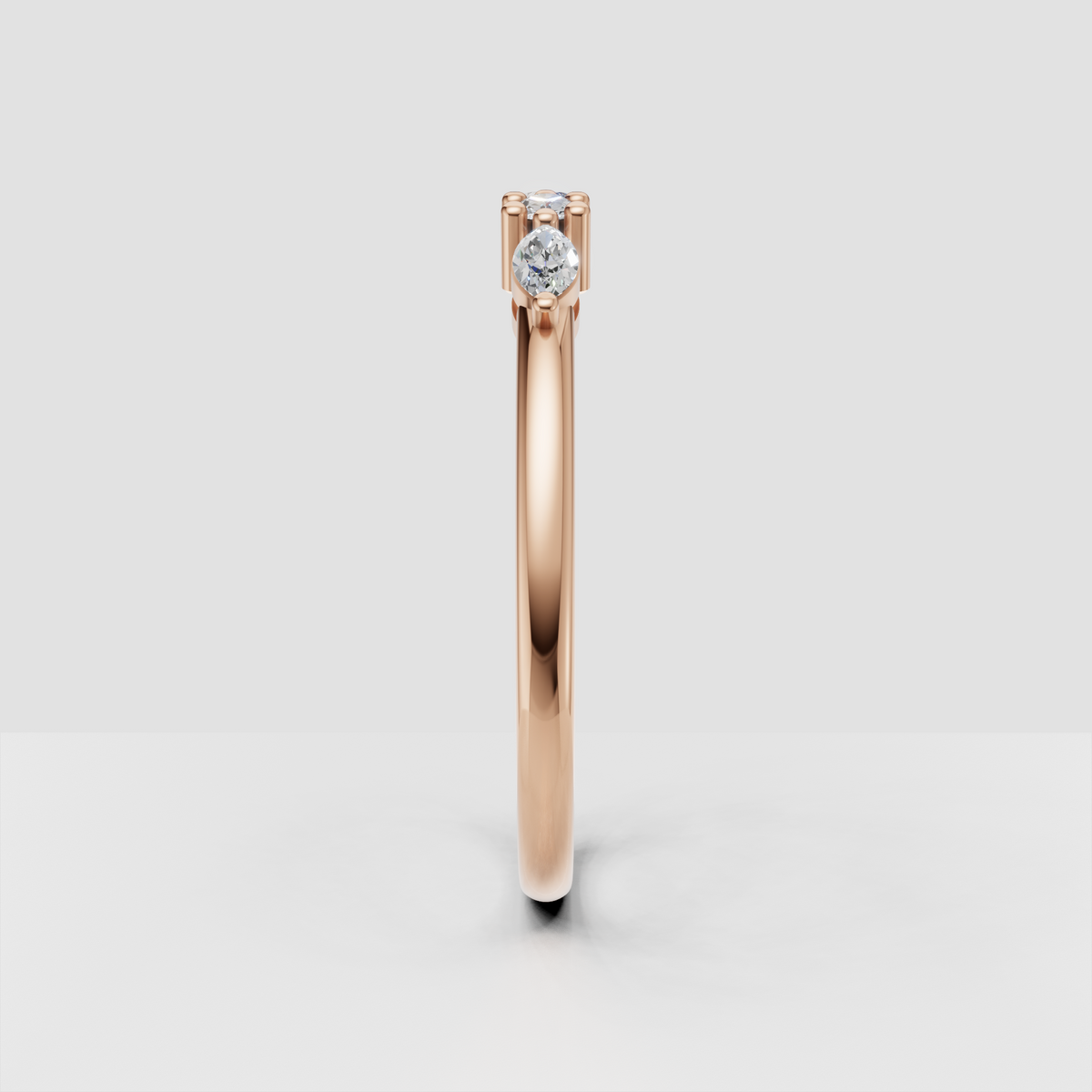 Close-up luxury jewellery image of a round and marquise diamond rose gold band
