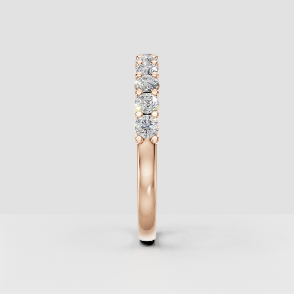 Side view of yellow gold eternity ring showing raised round diamond settings