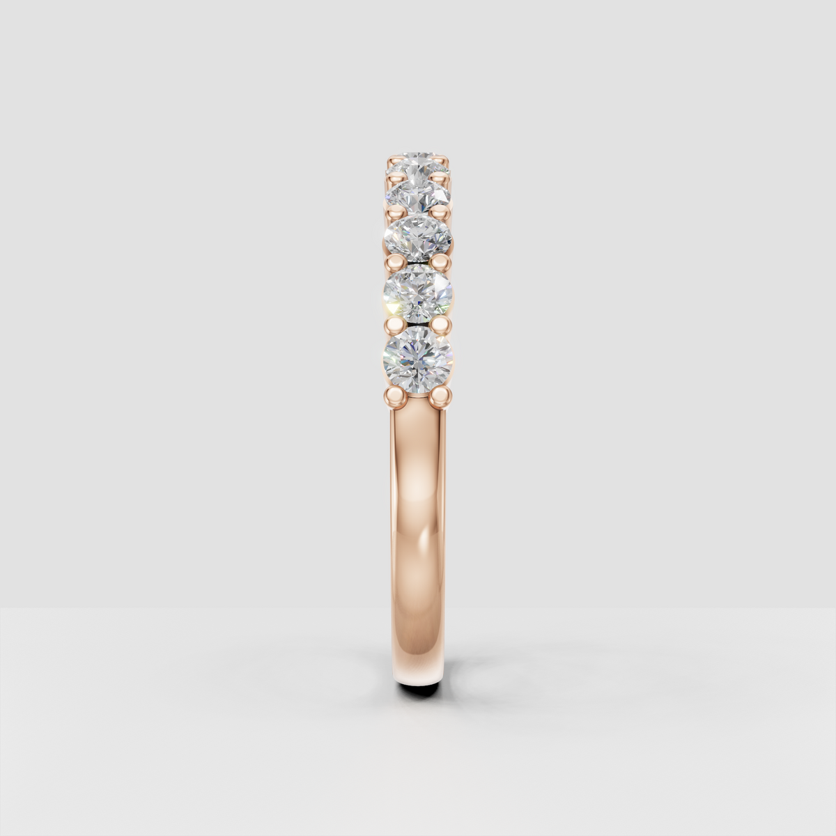 Side view of yellow gold eternity ring showing raised round diamond settings