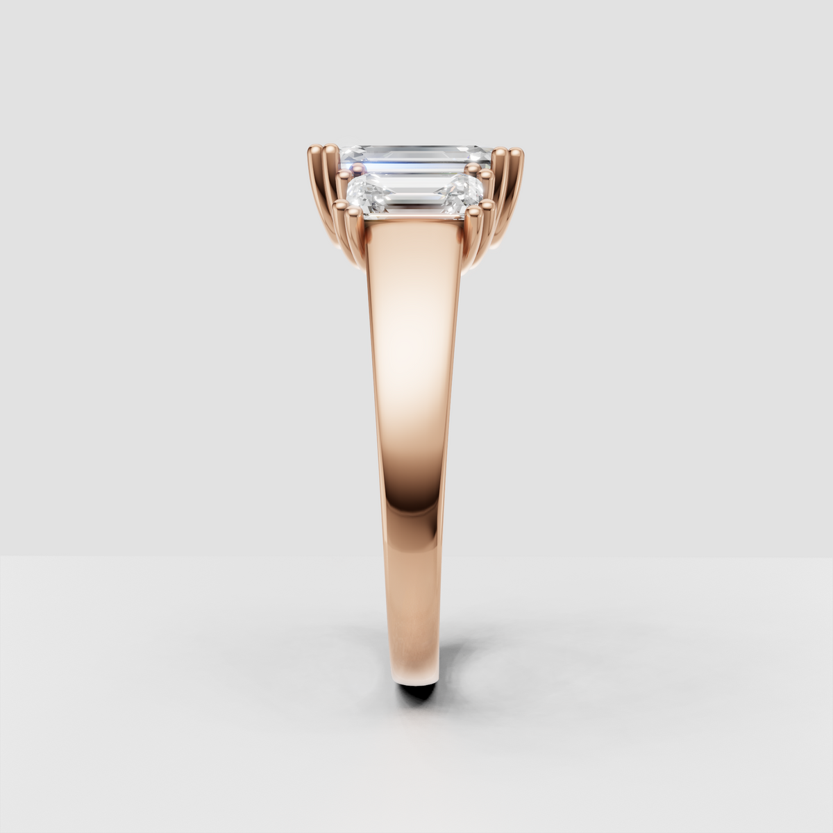 Emerald cut center stone framed by matching side Diamonds