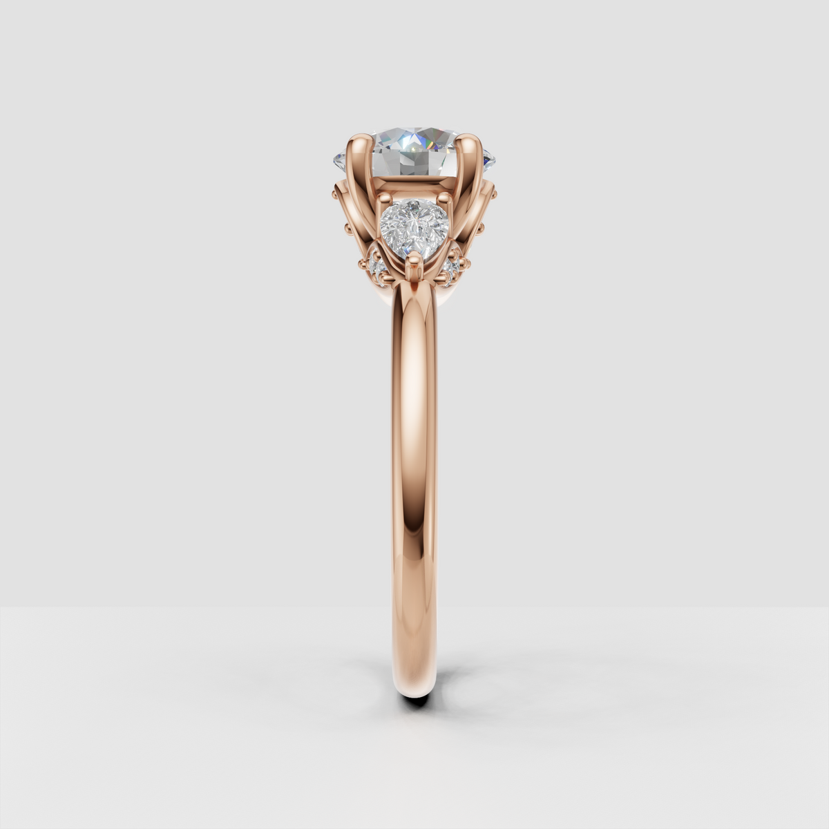 Round diamond ring featuring sculpted gold shoulders and side stones