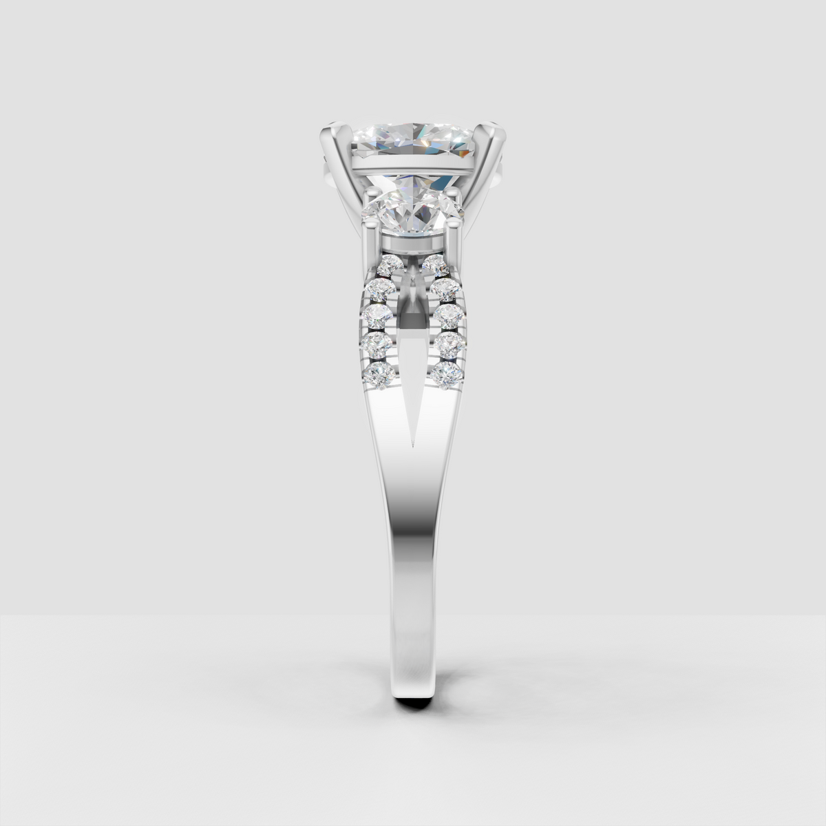Three stone engagement ring featuring oval center and oval side stones