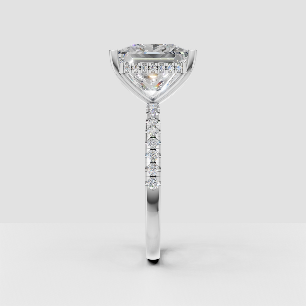 Princess diamond solitaire engagement ring with delicate pave-set round diamonds.
