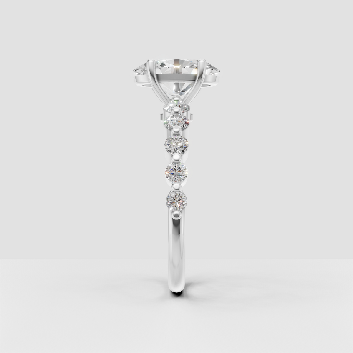Four prong oval diamond engagement ring with graduated round side diamonds