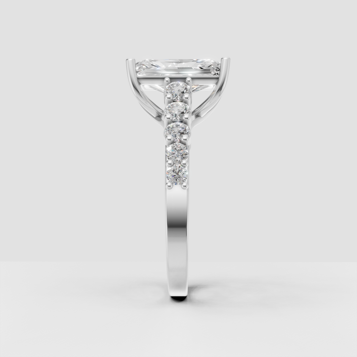 Elegant radiant cut ring with round pavé-style stones along the shoulders
