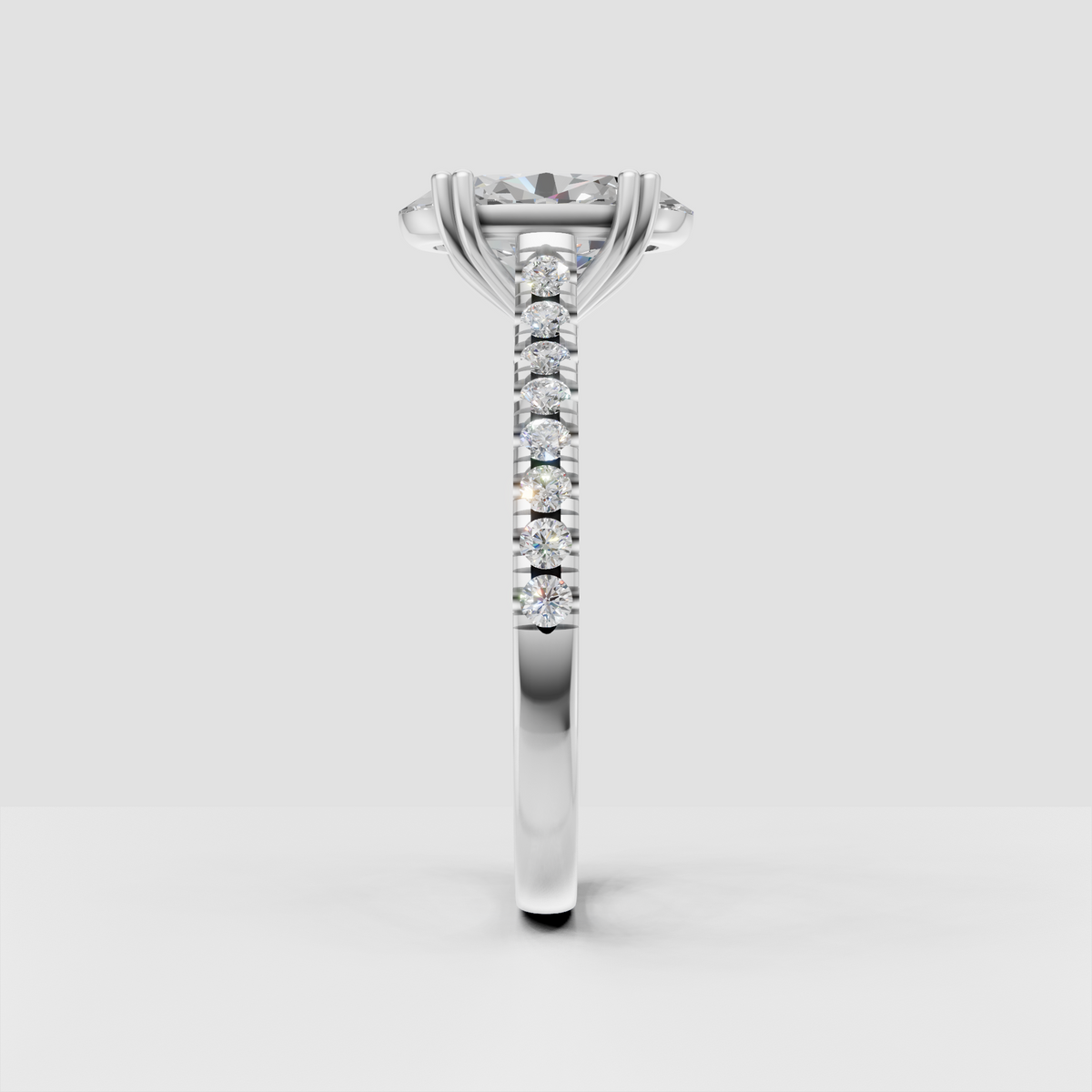 Four-prong oval diamond engagement ring with continuous side stone detailing