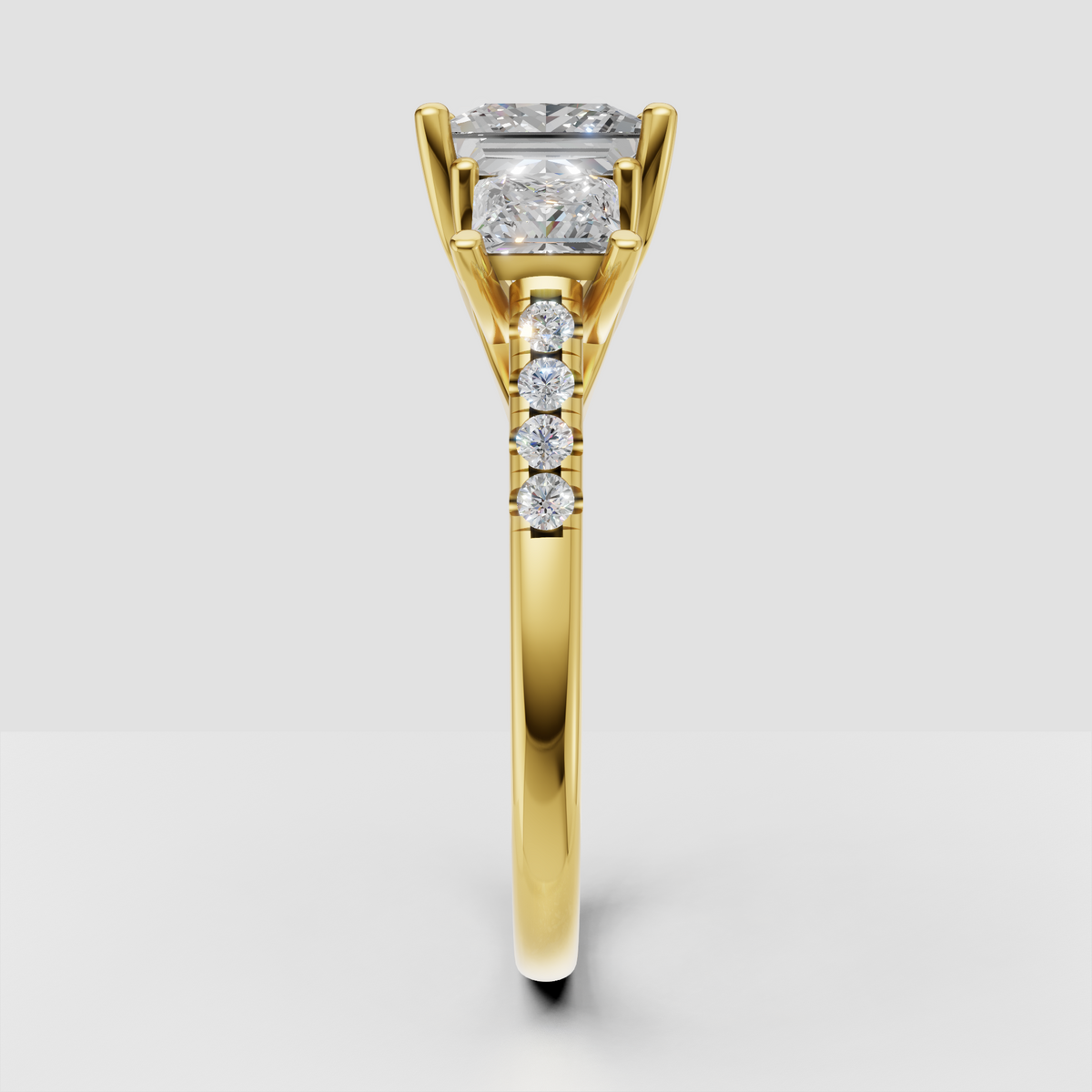 Three-stone princess diamond ring with pave accent band in yellow gold