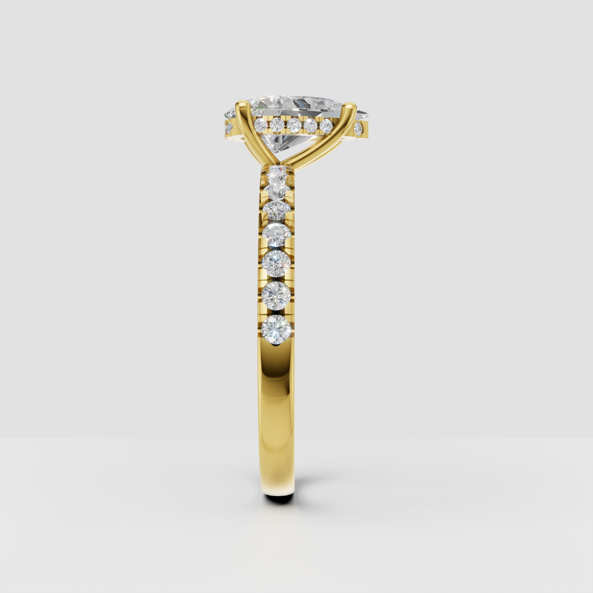 Yellow gold pear diamond ring with sparkling pavé shoulders