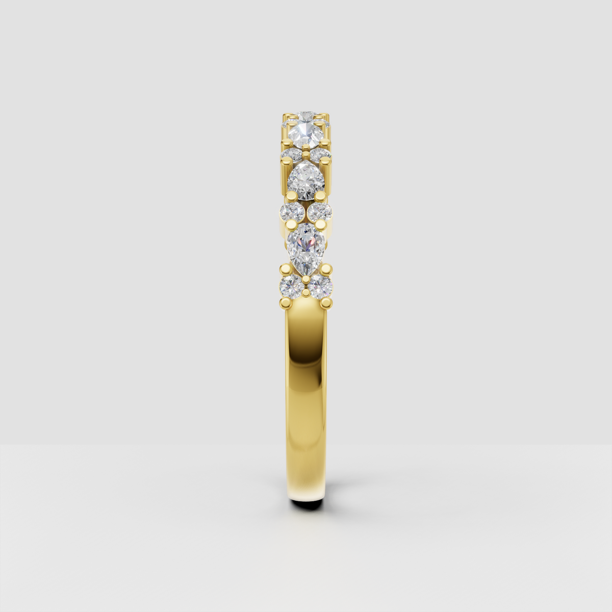 Alternating round and pear cut diamond wedding band in yellow gold