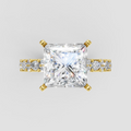 Princess cut diamond four-prong engagement ring with yellow gold band and side stones