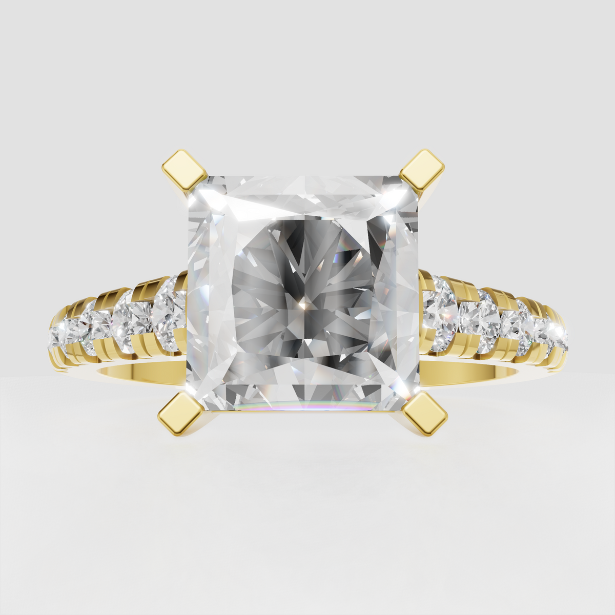 Radiant diamond four-prong engagement ring with pavé side stones in yellow gold